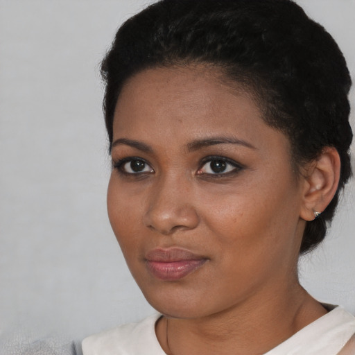 Joyful black young-adult female with short  brown hair and brown eyes