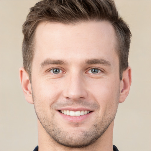 Joyful white young-adult male with short  brown hair and grey eyes