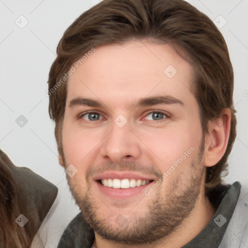 Joyful white young-adult male with short  brown hair and grey eyes