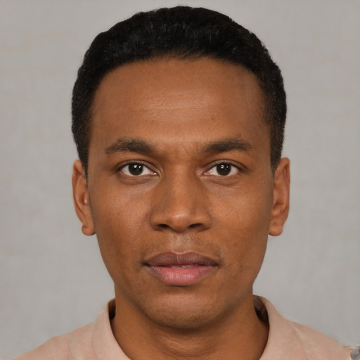 Joyful black young-adult male with short  black hair and brown eyes