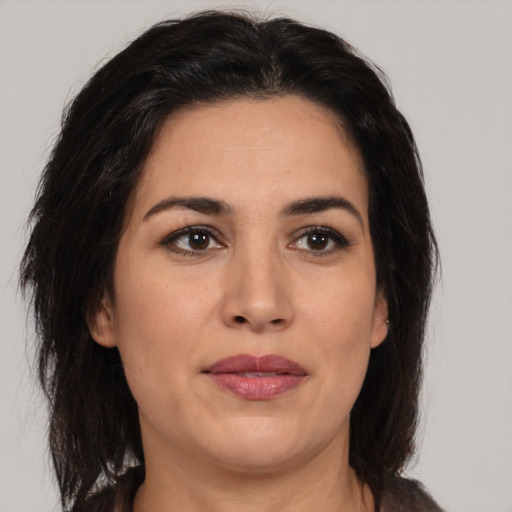 Joyful latino adult female with medium  brown hair and brown eyes