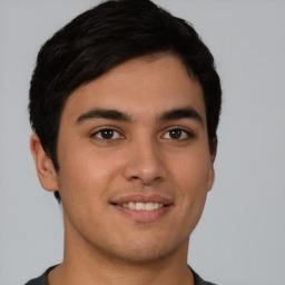 Joyful latino young-adult male with short  brown hair and brown eyes