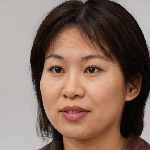 Joyful asian adult female with medium  brown hair and brown eyes
