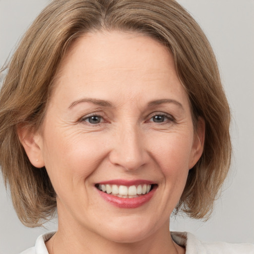 Joyful white adult female with medium  brown hair and brown eyes