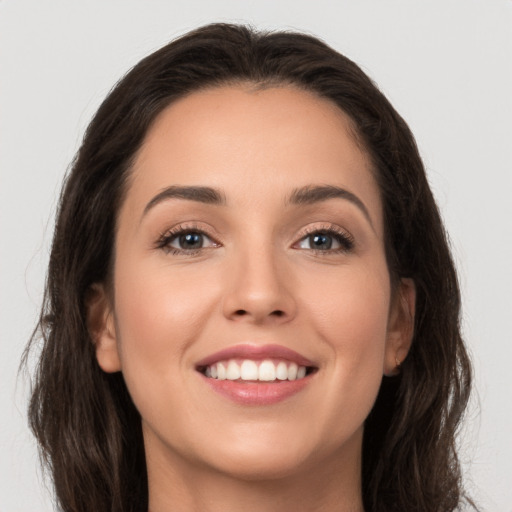 Joyful white young-adult female with long  brown hair and brown eyes