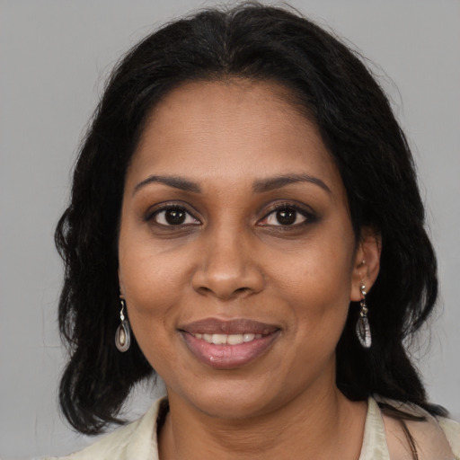 Joyful black adult female with long  brown hair and brown eyes