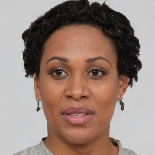 Joyful black adult female with short  brown hair and brown eyes