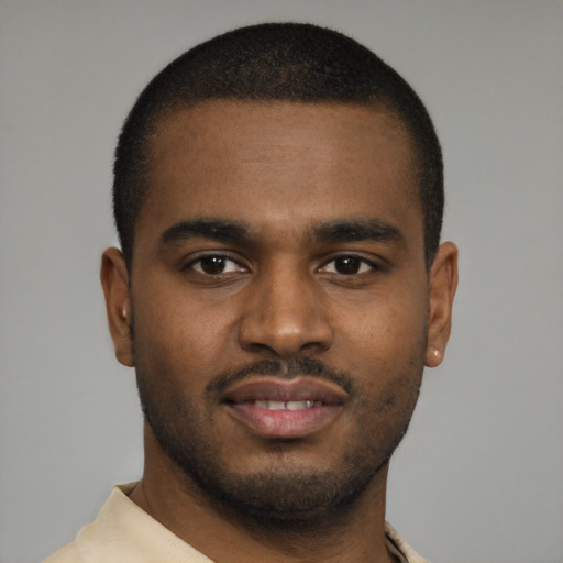 Joyful black young-adult male with short  brown hair and brown eyes