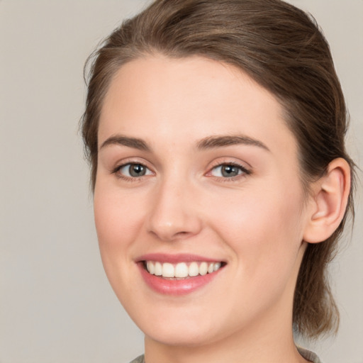 Joyful white young-adult female with medium  brown hair and green eyes