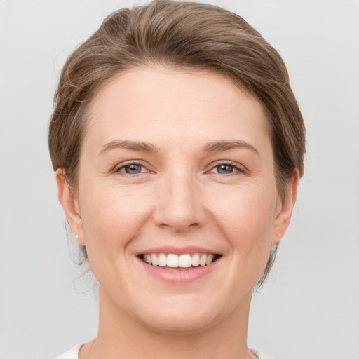 Joyful white young-adult female with short  brown hair and grey eyes