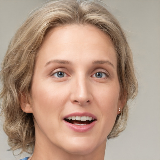 Joyful white young-adult female with medium  brown hair and blue eyes