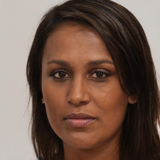 Joyful black young-adult female with long  brown hair and brown eyes