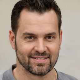 Joyful white adult male with short  brown hair and brown eyes