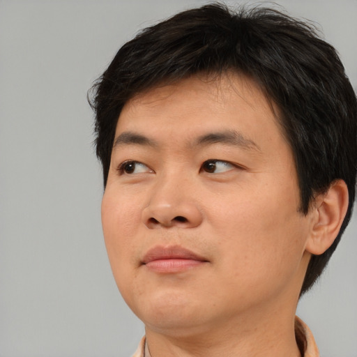Joyful asian young-adult male with short  brown hair and brown eyes