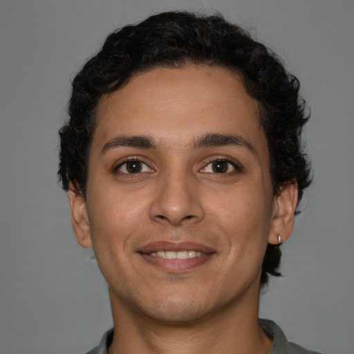 Joyful latino young-adult male with short  brown hair and brown eyes