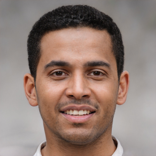 Joyful black young-adult male with short  black hair and brown eyes