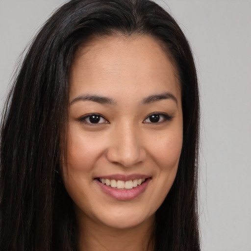 Joyful asian young-adult female with long  brown hair and brown eyes