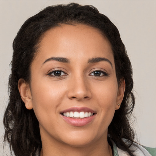 Joyful latino young-adult female with long  brown hair and brown eyes