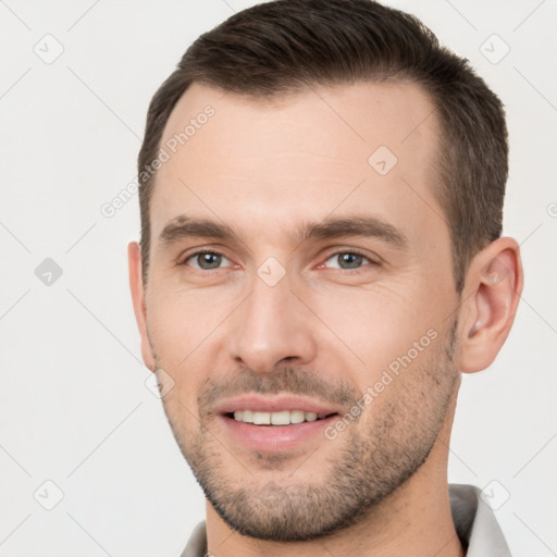 Joyful white young-adult male with short  brown hair and brown eyes