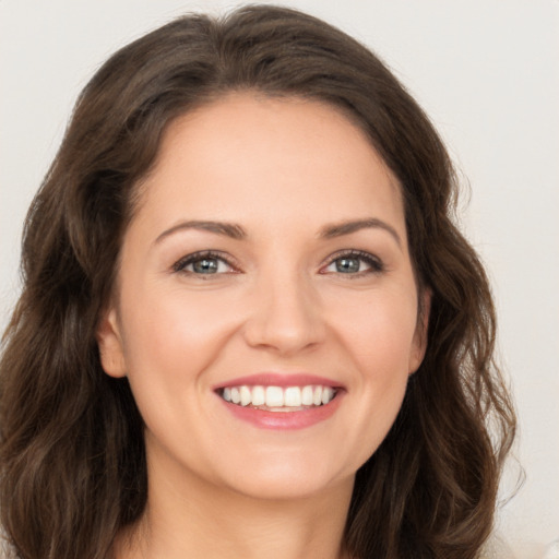 Joyful white young-adult female with long  brown hair and green eyes