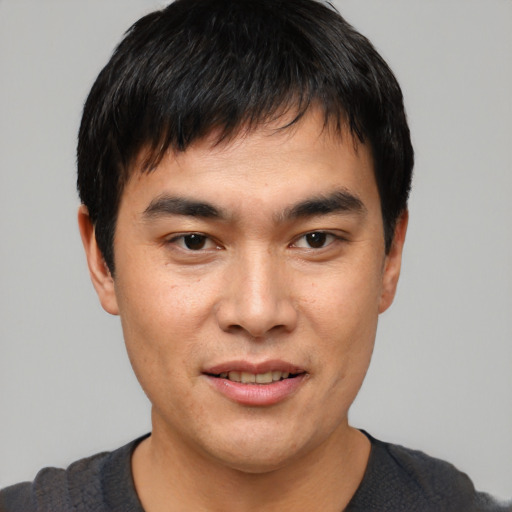 Joyful asian young-adult male with short  black hair and brown eyes