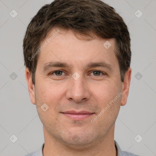 Joyful white young-adult male with short  brown hair and grey eyes