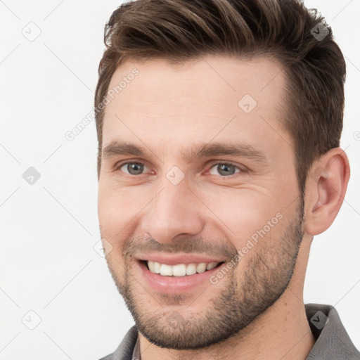 Joyful white young-adult male with short  brown hair and grey eyes