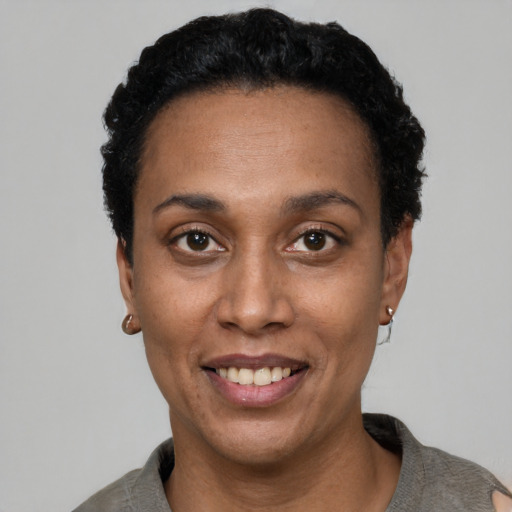 Joyful black adult female with short  black hair and brown eyes