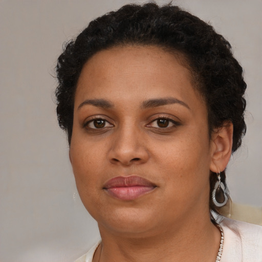 Joyful black young-adult female with short  brown hair and brown eyes