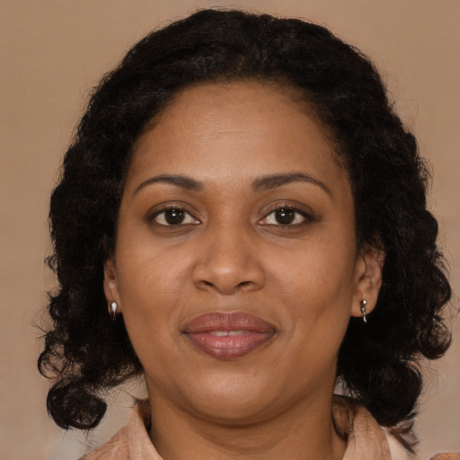 Joyful black adult female with medium  brown hair and brown eyes