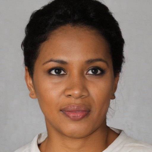 Joyful black young-adult female with short  black hair and brown eyes