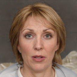 Joyful white adult female with medium  brown hair and blue eyes