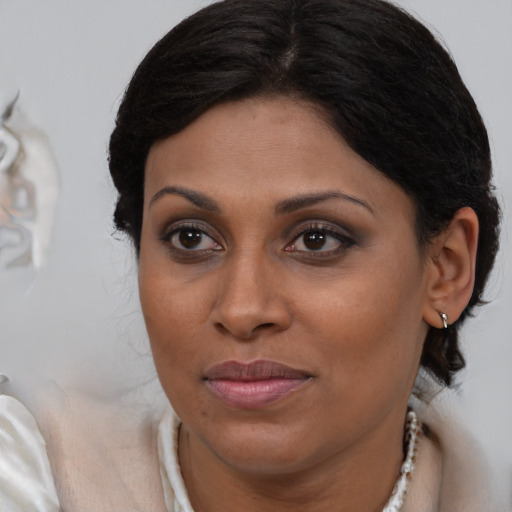 Joyful latino adult female with medium  brown hair and brown eyes