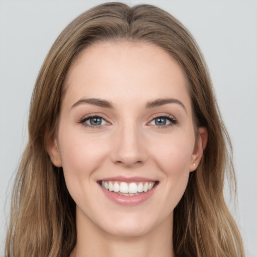 Joyful white young-adult female with long  brown hair and grey eyes