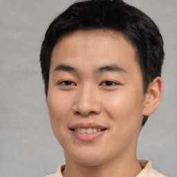 Joyful asian young-adult male with short  black hair and brown eyes