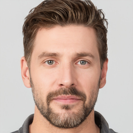 Joyful white young-adult male with short  brown hair and grey eyes