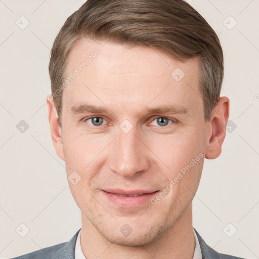 Joyful white young-adult male with short  brown hair and grey eyes