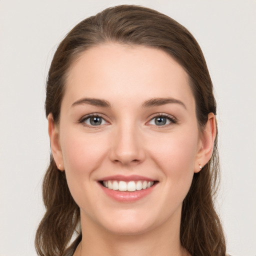 Joyful white young-adult female with long  brown hair and green eyes