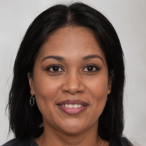 Joyful latino adult female with long  brown hair and brown eyes