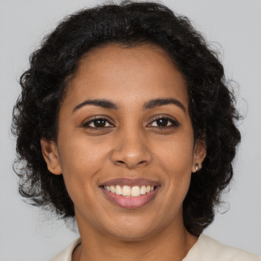Joyful black young-adult female with long  brown hair and brown eyes