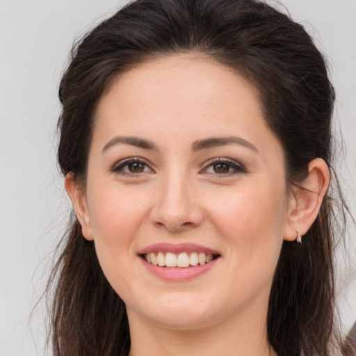 Joyful white young-adult female with long  brown hair and brown eyes