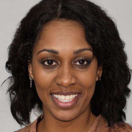 Joyful black young-adult female with long  brown hair and brown eyes