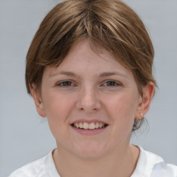 Joyful white young-adult female with medium  brown hair and grey eyes