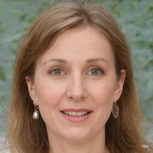 Joyful white adult female with long  brown hair and green eyes