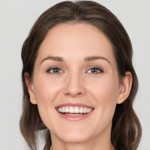 Joyful white young-adult female with medium  brown hair and grey eyes