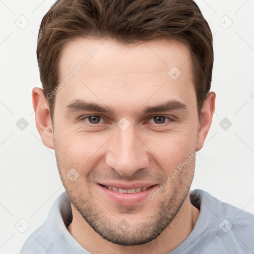 Joyful white young-adult male with short  brown hair and grey eyes