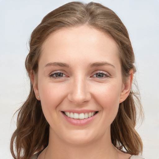 Joyful white young-adult female with medium  brown hair and grey eyes