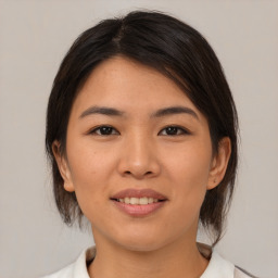 Joyful asian young-adult female with medium  brown hair and brown eyes