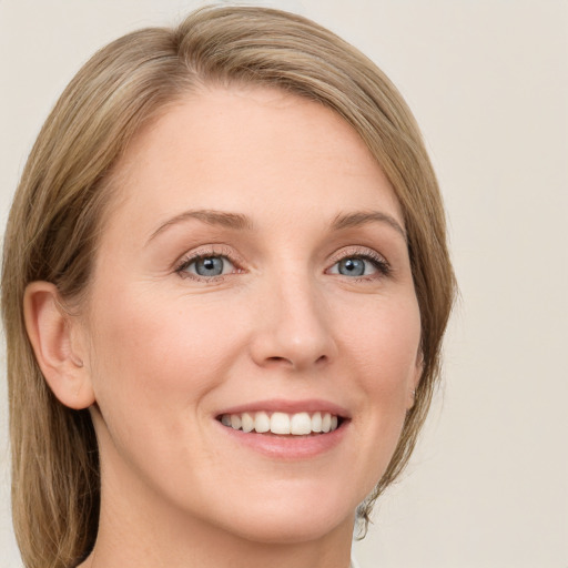 Joyful white young-adult female with medium  brown hair and green eyes