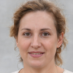 Joyful white adult female with medium  brown hair and brown eyes